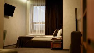 ein Hotelzimmer mit einem Bett und einem Fenster in der Unterkunft MOJO HALL Hotel in Luzk