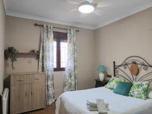1 dormitorio con 1 cama y ventilador de techo en Relax, vistas, barbacoa y piscina, junto a Ronda en Arriate
