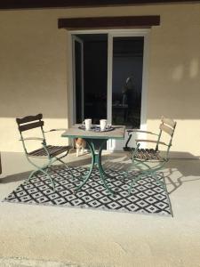 Duas cadeiras e uma mesa com duas chávenas. em Guest house « Cantegrit » em Ychoux