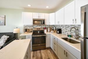una cocina con armarios blancos y fregadero en D Sands Rentals en Lincoln City