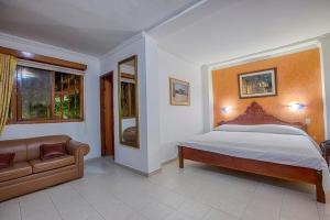 um quarto com uma cama e um sofá em Baluarte Cartagena Hotel Boutique em Cartagena de Indias