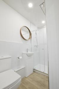 La salle de bains blanche est pourvue d'une douche et de toilettes. dans l'établissement Viewpoint East, à Dunollie