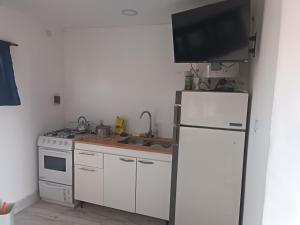 a kitchen with a refrigerator and a tv on the wall at 2 Duplex camet norte santa clara del mar in Camet Norte