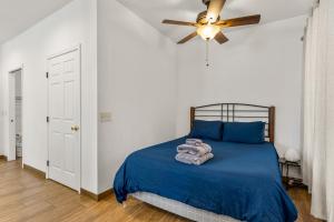 a bedroom with a bed with blue sheets and a ceiling fan at Greenlaw Studio in the Pines! in Flagstaff