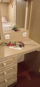 a wooden desk with flowers on it in a bedroom at Kupai Apartman in Tiszaújváros