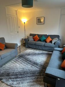 a living room with two couches and a rug at Watergall Lodge in Peterborough