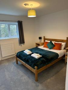 a bedroom with a bed with two towels on it at Watergall Lodge in Peterborough