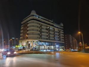 a building at night with a car driving past it at Apartment 06 in Gjilan