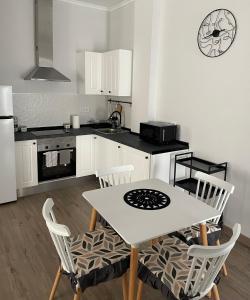uma cozinha com uma mesa e cadeiras numa cozinha em Maison Sereine em Valência