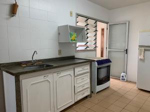 a kitchen with a sink and a refrigerator at Apartamento no Centro para 7 pessoas in Campo Grande