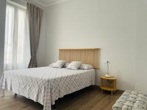 1 dormitorio con 1 cama con edredón blanco en Maison Sereine en Valencia