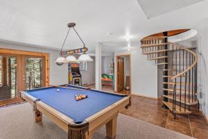 a living room with a pool table and a staircase at Lovely & Rustic TreeHouse Cabin - Stargazing in the Pines! in Mountainaire