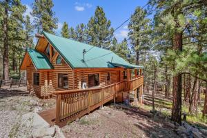 a log cabin in the woods with a green roof at Lovely & Rustic TreeHouse Cabin - Stargazing in the Pines! in Mountainaire