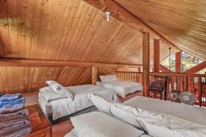 a room with two beds in a wooden cabin at Lovely & Rustic TreeHouse Cabin - Stargazing in the Pines! in Mountainaire