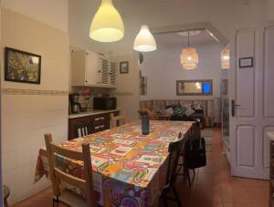 a kitchen with a table with a colorful table cloth at Peniche Hostel in Peniche