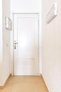 Una puerta blanca en una habitación blanca con suelo de baldosa. en Sol apartment with amazing seaview, en Adeje