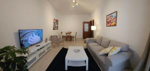 a living room with a couch and a tv at CASA BLANCA-Parking gratis in Sanlúcar de Barrameda +38 photos