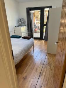 um quarto com uma cama e piso em madeira em N8, Modern 2 bedroom Apartment em Londres