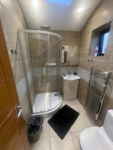 uma casa de banho com um chuveiro, um WC e um lavatório. em N8, Modern 2 bedroom Apartment em Londres