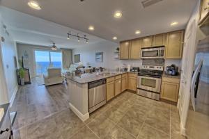 a kitchen with wooden cabinets and a view of the ocean at OCEAN FRONT CONDO w INCREDIBLE VIEWS in Panama City Beach