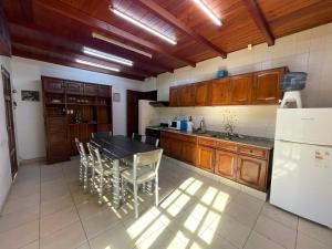 una cocina con armarios de madera, mesa y sillas en Casa Quinta La Falda Cordoba en La Falda