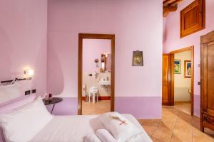 a bedroom with purple walls and a bed with a mirror at B&B La Casa di Assunta in Acquaviva