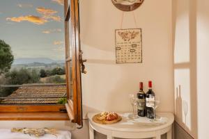 a room with a table with wine glasses and a window at B&B La Casa di Assunta in Acquaviva