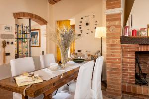 a dining room with a wooden table and white chairs at B&B La Casa di Assunta in Acquaviva