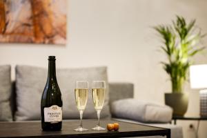 a bottle of champagne and two wine glasses on a table at RIGAAPARTMENT ELIZABETES 22 Self-Service Aparthotel in Riga