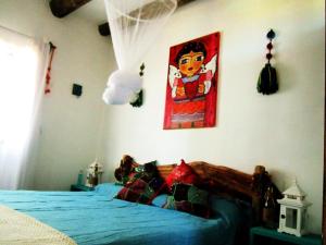 a bedroom with a bed and a painting on the wall at Rico Pino eco posada in La Pedrera