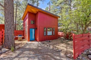a red shed with a blue door in the woods at Enchanting & Newly Built NoHo 1 BDR Loft with AC! in Flagstaff