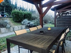 einen Holztisch und Stühle auf einer Terrasse in der Unterkunft Appartement à 2 mins du centre in Sarlat-la-Canéda