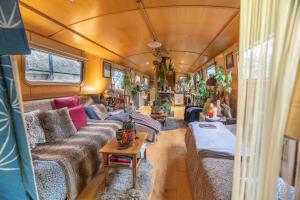 a living room in a bus with couches and a table at Floating Cat Palace in the Heart of Bath in Bath