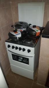 - une cuisinière avec des casseroles et des poêles dans l'établissement Annex House For Rent, à Manjai Kunda