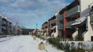 a snow covered street in front of a building at Apartament Lubię Morze in Jantar