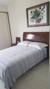 a bed with a wooden headboard in a bedroom at Luxury apartment in the most privileged area - SC in Santa Cruz de la Sierra