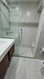 a white bathroom with a shower and a sink at Luxury apartment in the most privileged area - SC in Santa Cruz de la Sierra