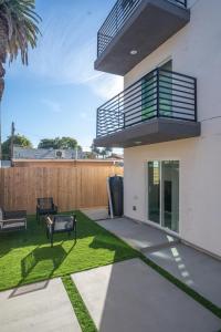 a backyard with a balcony and grass at Normandie Hostel in Los Angeles