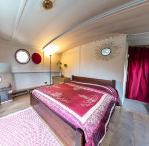 a bedroom with a large bed with pink sheets at Off-Grid Living on Spacious Widebeam in Bath