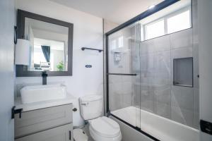 a bathroom with a shower and a toilet and a sink at Normandie Hostel in Los Angeles