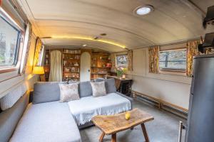 a living room of a train with a couch and a table at Off-Grid Living on Spacious Widebeam in Bath
