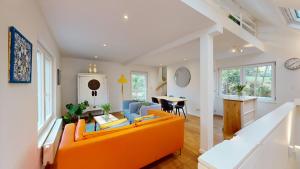 sala de estar con sofá naranja y mesa en The Tile House - 2 bedroom property just south of Brussels, en Sint-Genesius-Rode