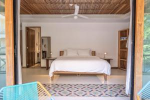 a bedroom with a white bed and a balcony at Casa Pepe in Sayulita