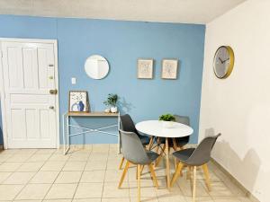 ein Esszimmer mit einer blauen Wand sowie einem Tisch und Stühlen in der Unterkunft Depas & Suites JUAREZ in Ciudad Juárez