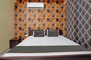 巴特那的住宿－OYO Flagship Welcome 24x7，一间卧室配有床和一张带照片的墙壁