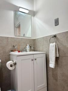 ein Badezimmer mit einem weißen Waschbecken und einem Spiegel in der Unterkunft Depas & Suites JUAREZ in Ciudad Juárez