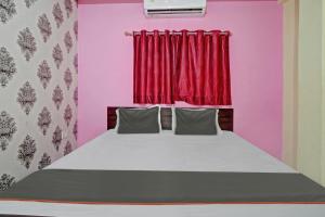 a bedroom with a bed with a red curtain at OYO Flagship Welcome 24x7 in Patna