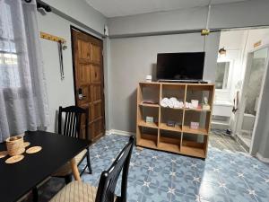 a dining room with a table and a television at Udon House in Udon Thani