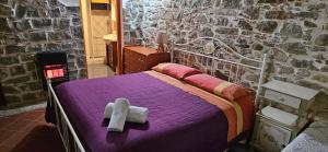 una camera con un letto in una parete in pietra di Stone house a Montalbano Elicona