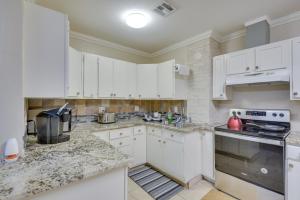 a kitchen with white cabinets and marble counter tops at Cozy Oklahoma City Home with Deck and Gas Grill! in Oklahoma City